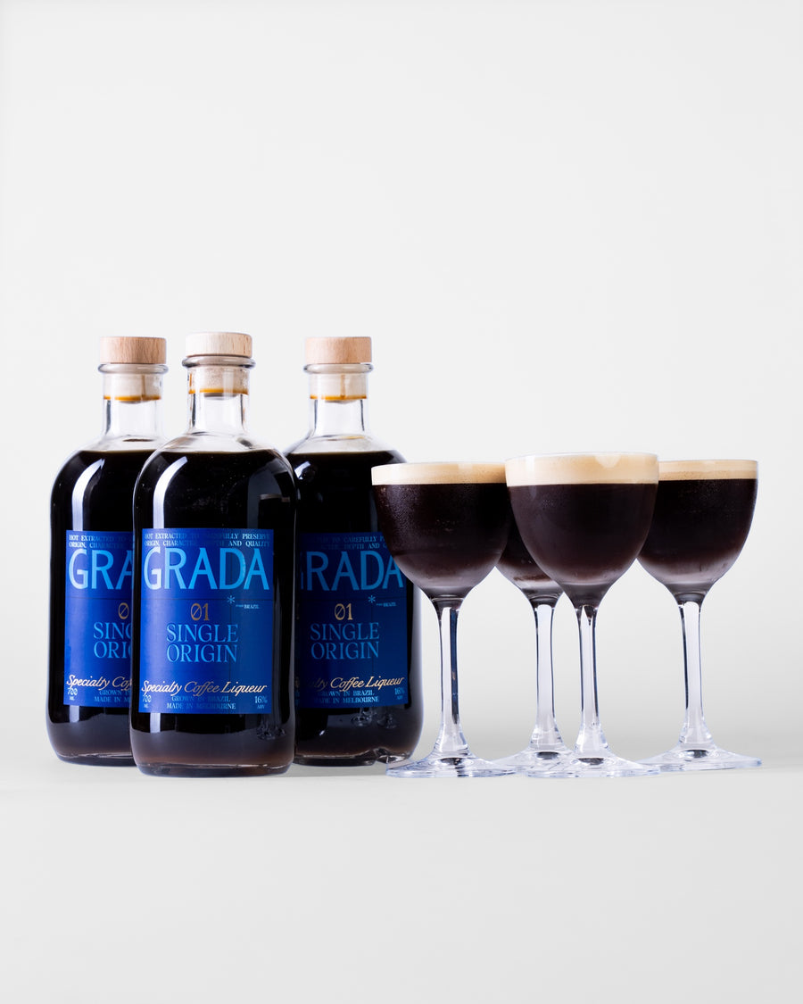Three bottles of GRADA 01 Single Origin with three espresso martinis in Nick & Nora glasses