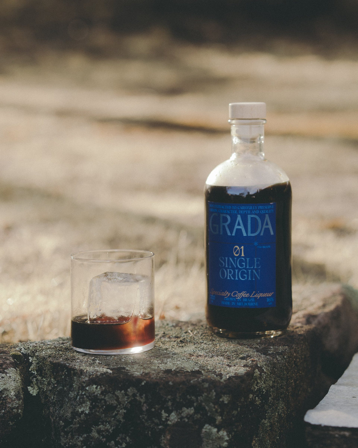 GRADA 01 Single Origin and a glass over ice on a rock in the Australian bush