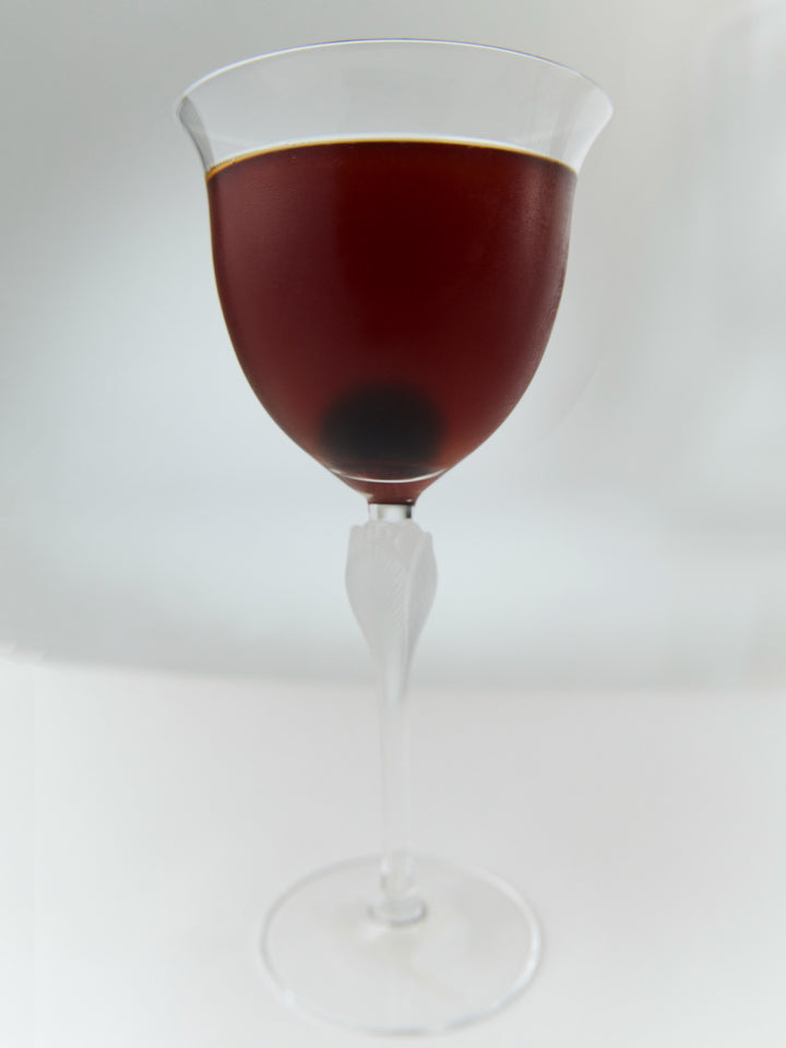 A GRADA Manhattan strained into a stemmed glass with a cherry