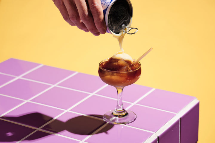 Sweetened condensed milk poured over a frozen GRADA iced coffee in a coupe