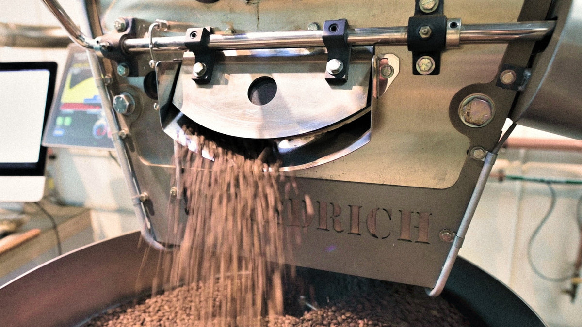 Roasted coffee dropping from the drum into the cooling tray at Criteria Coffee