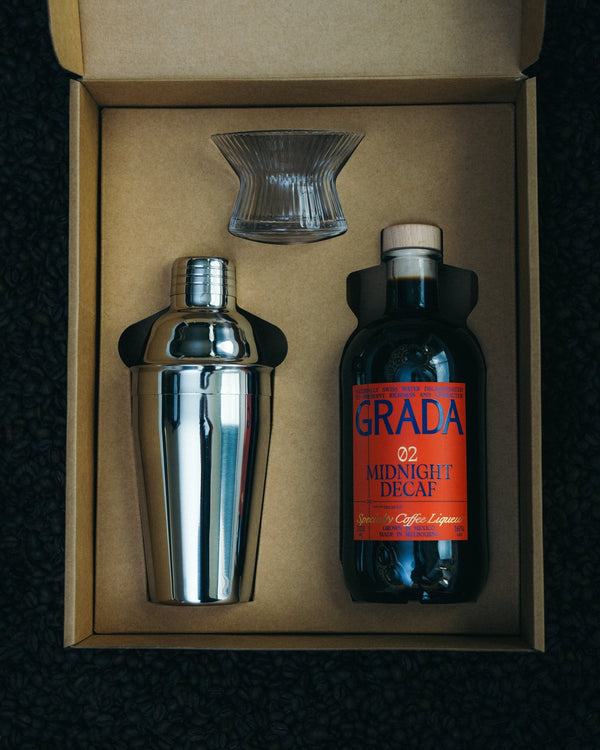 The GRADA 02 Midnight Decaf gift box, open, with the bottle, a cocktail shaker and a coupe