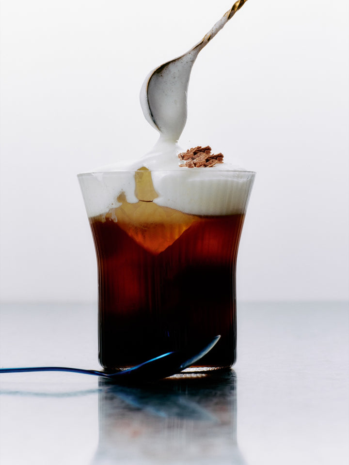 An iced GRADA Café Freddo under a float of hot milk foam and grated chocolate