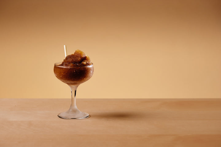 A frozen GRADA espresso martini served in a coupe with a straw
